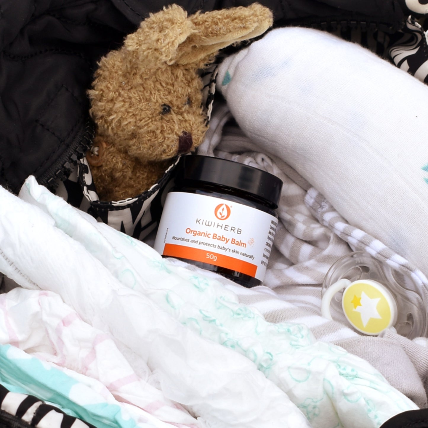 Kiwiherb Organic Baby Balm in a baby bag.